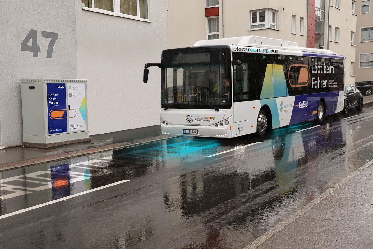 Sebuah bus listrik dicat hitam putih melaju di jalan basah di Jerman.